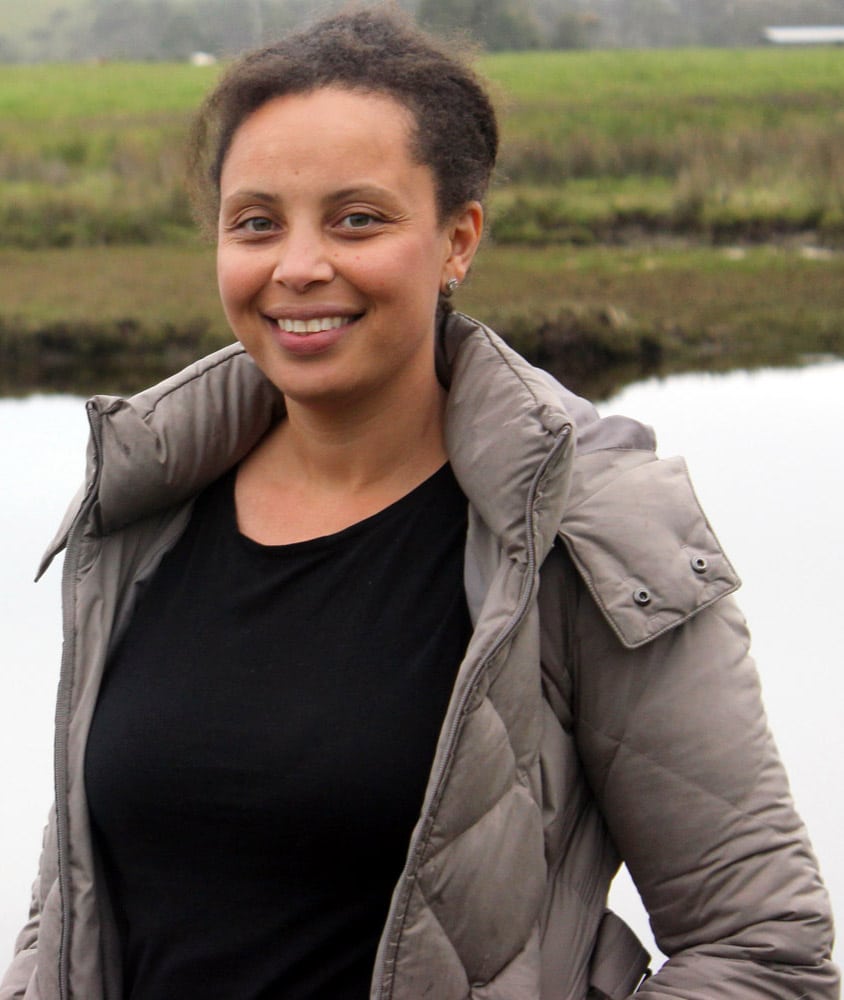 Robyn Leigh standing in front of Tasmanian creek